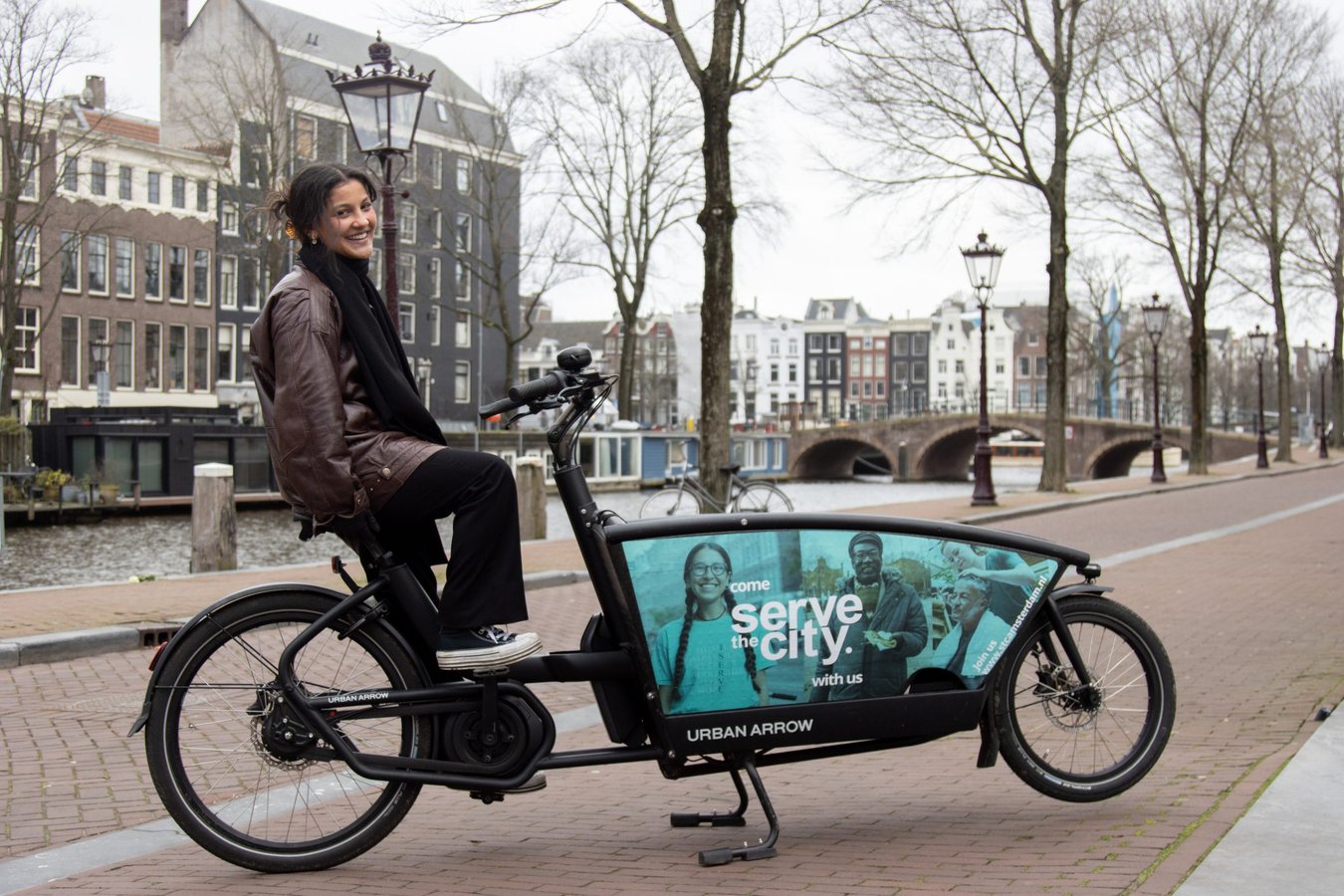 Rider op bakfiets langs Amsterdamse gracht
