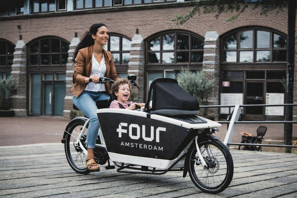 Moeder rijdt bakfiets door de stad