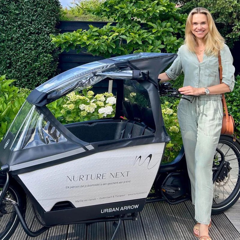 Vrouw met Urban Arrow bakfiets met merksticker